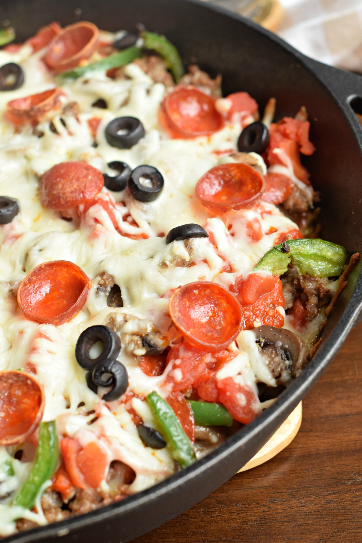 Cast iron skillet with supreme pizza toppings and no crust.