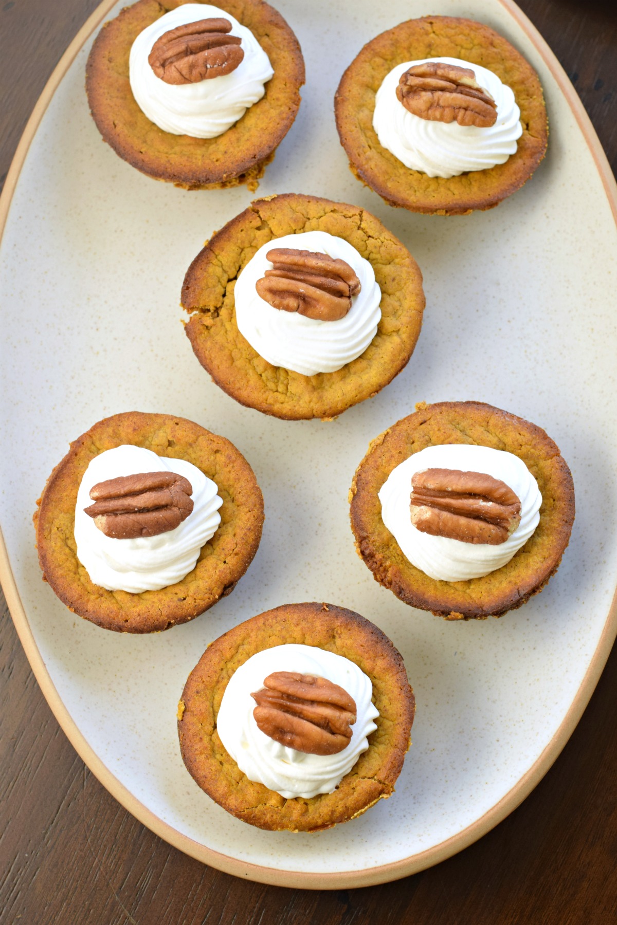 Pumpkin pie minis with whipped cream and pecans.