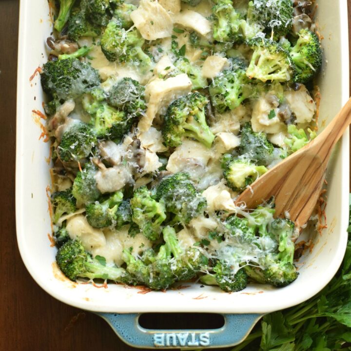 Broccoli chicken casserole in baking dish with wooden spoon.