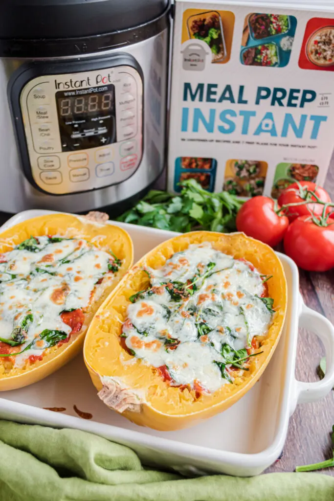 Spaghetti squash lasagna boats with cookbook and instant pot in background.