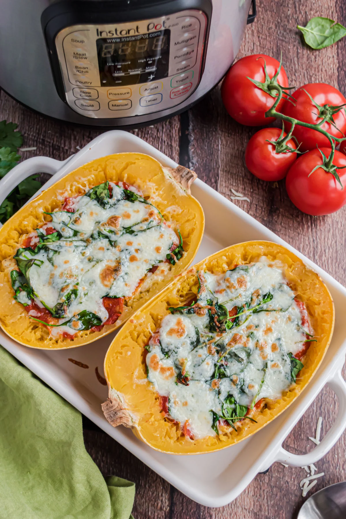 Spaghetti squash halves in a baking dish topped with melted cheese.