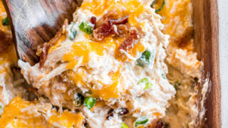 Jalapeno popper chicken casserole recipe in a dish with a spoon to serve.
