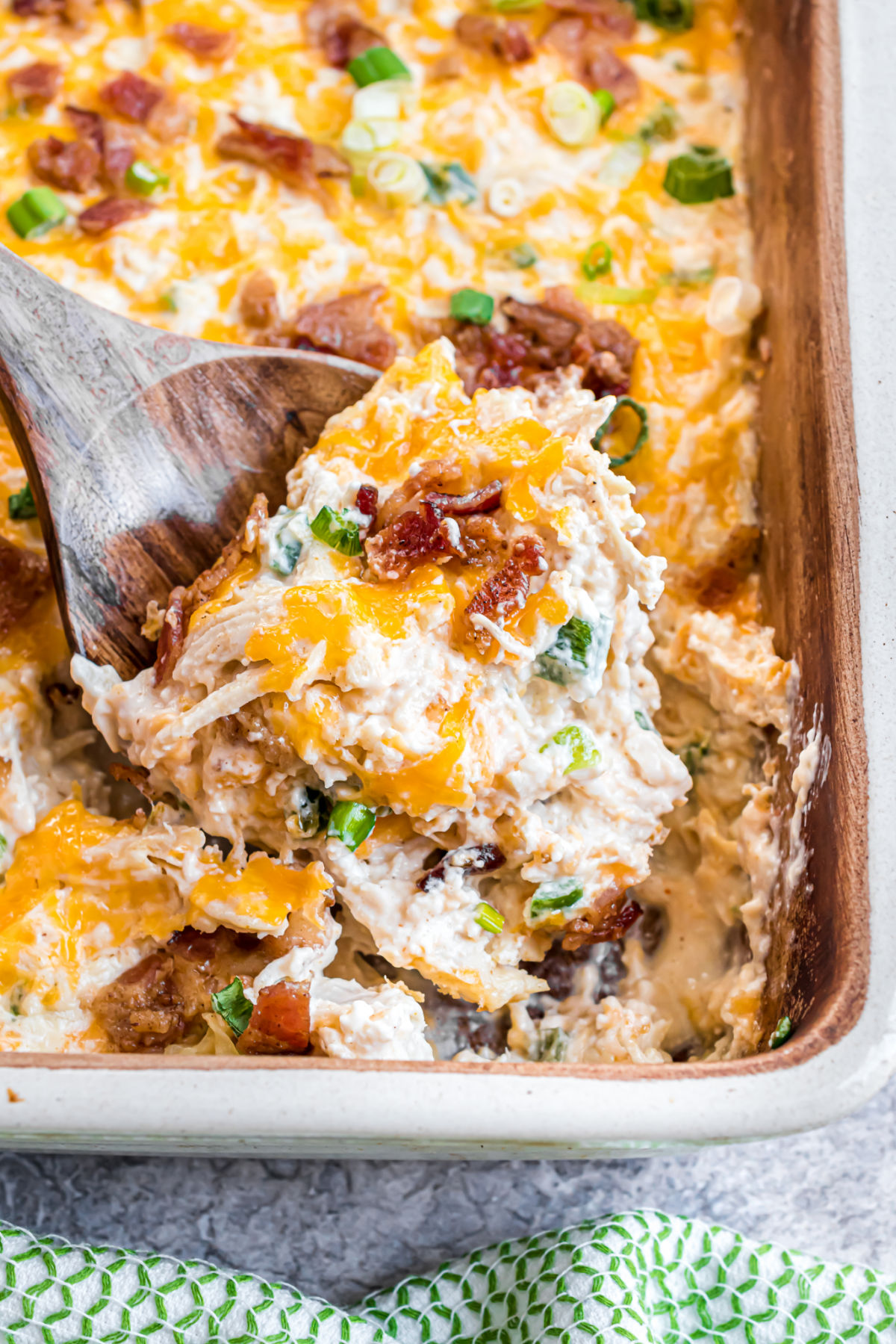 Jalapeno popper chicken casserole recipe in a dish with a spoon to serve. 
