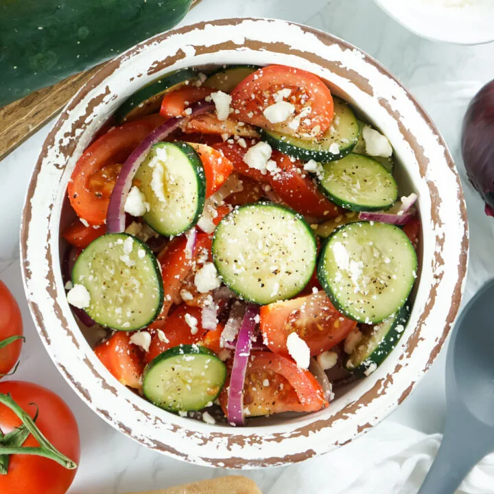 Cucumber tomato salad in a bowl with feta cheese.