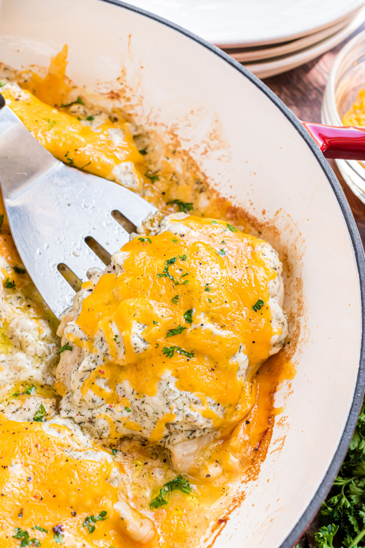 Baked chicken with ranch sauce and cheese in skillet.