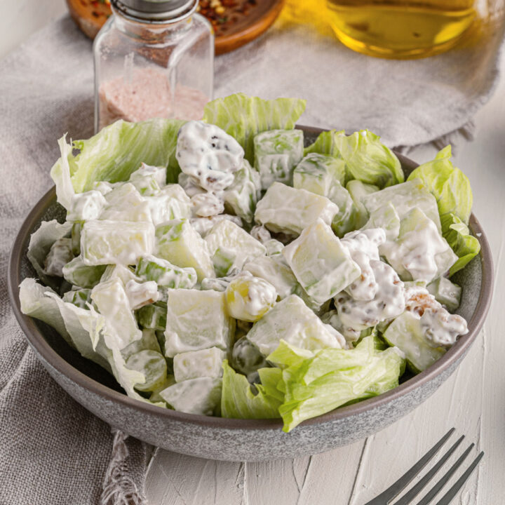 Waldorf salad in a bowl lined with lettuce.