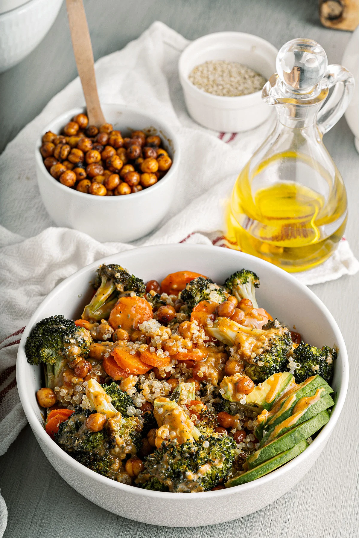 Broccoli buddha bowl in a white serving bowl with chickpeas on the side.