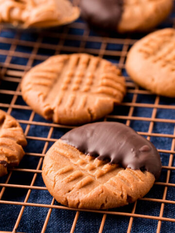 Sugar free chocolate dipped keto peanut butter cookies on wire rack.