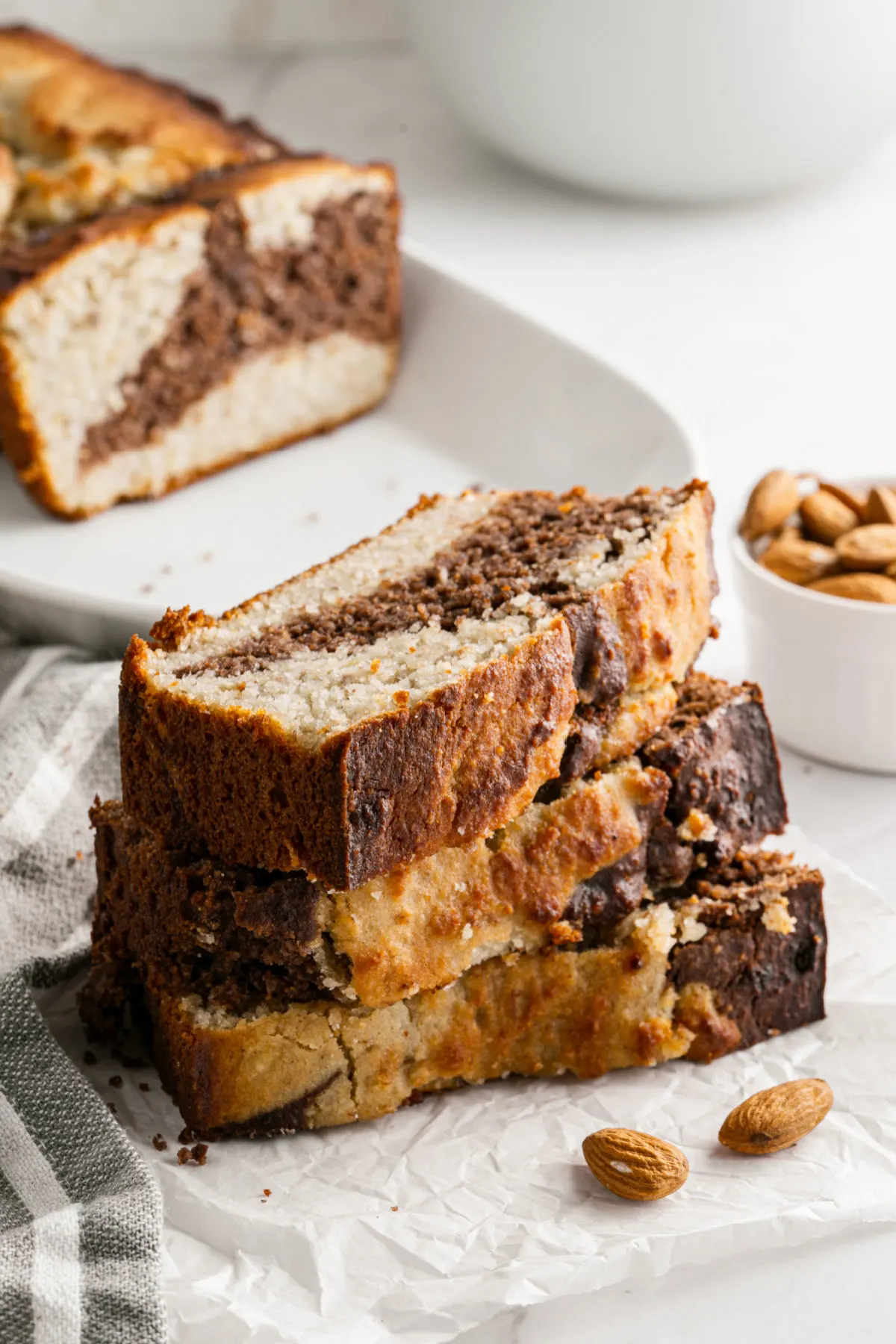 Three slices of sugar free banana bread stacked on plate.