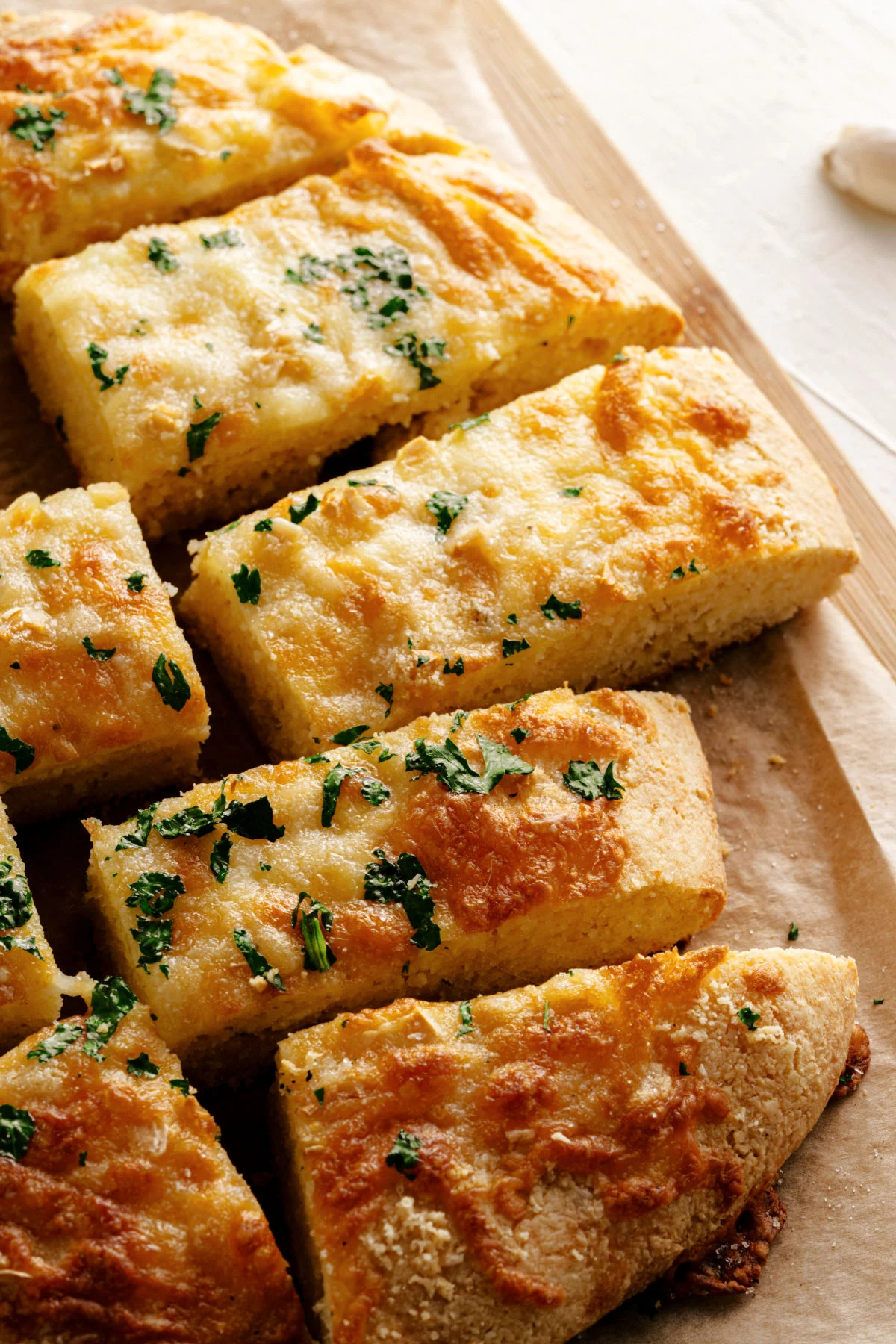 Parchment paper with gluten free garlic bread cut into pieces.