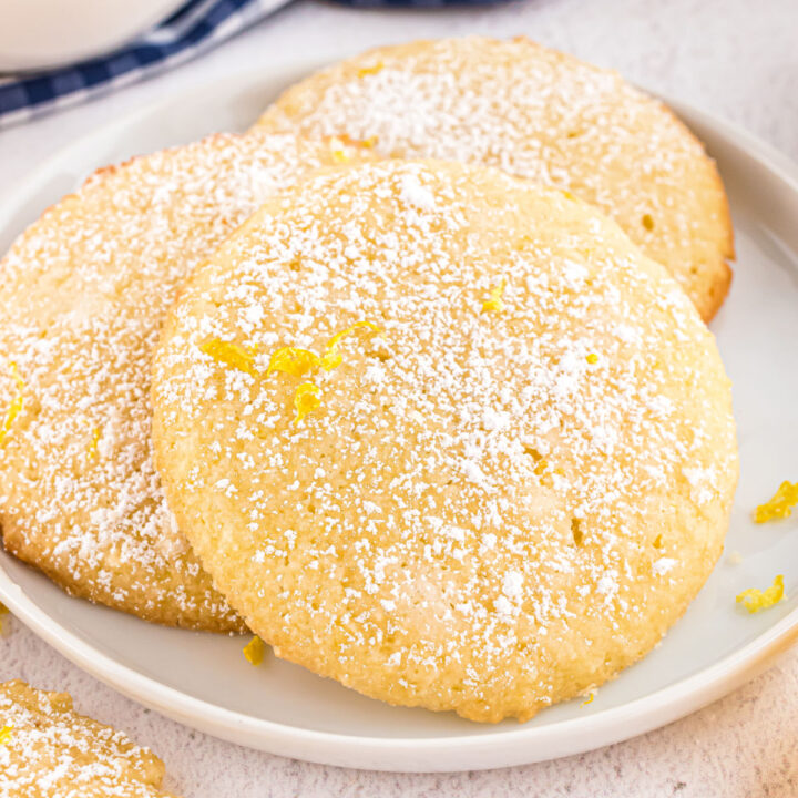 Three lemon cookies on a white dessert plate.