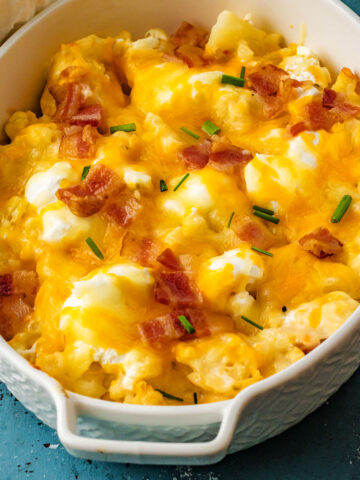 Loaded Cauliflower Casserole has all the satisfying flavor of loaded potatoes. And none of the carbs! Steamed cauliflower is topped with bacon, cheese and sour cream for a hearty side dish. Cauliflower never tasted so good!