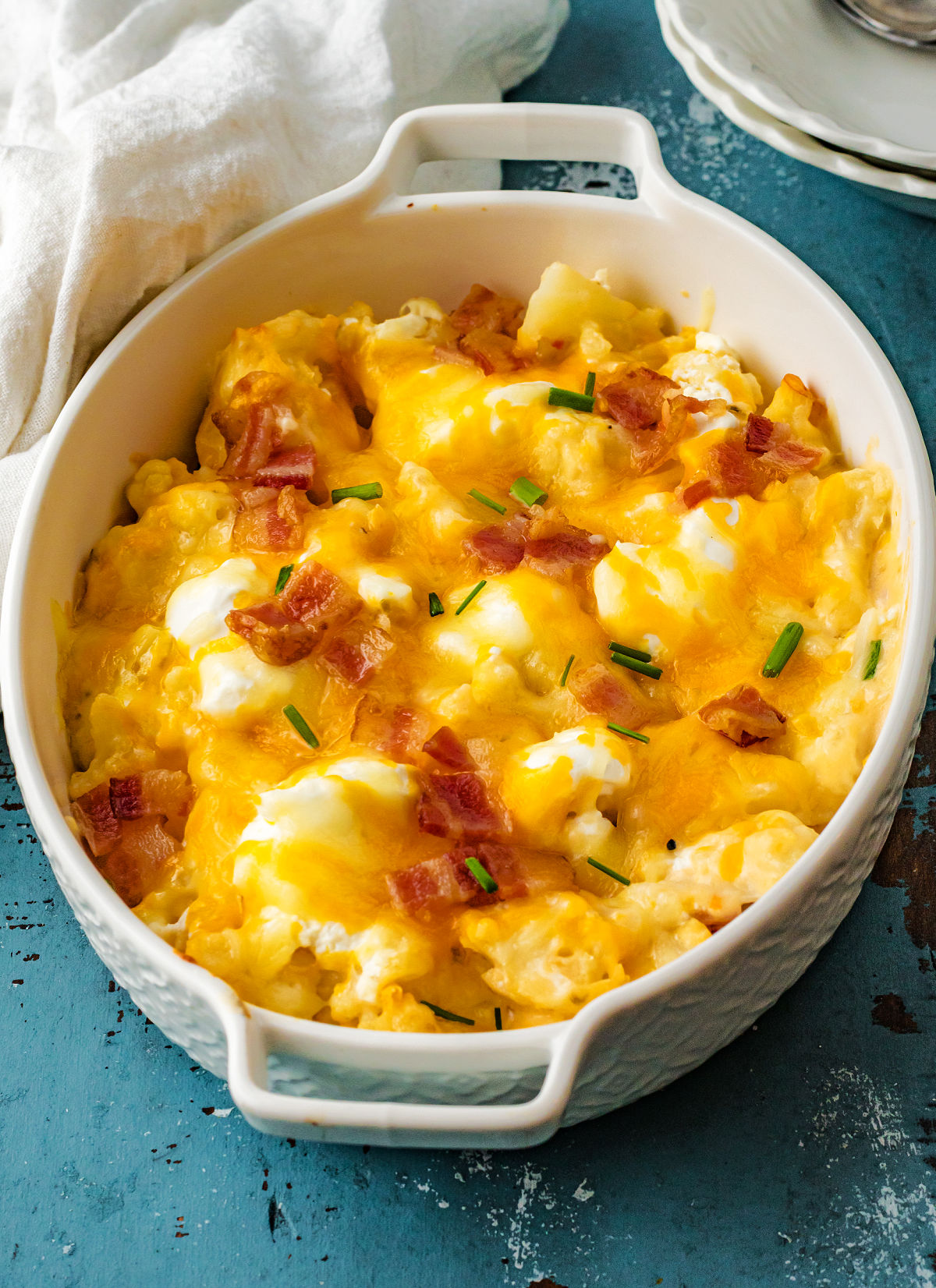 Oval casserole dish with cheese and bacon and cauliflower. 