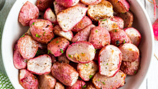 Roasted radishes in a white serving bowl.
