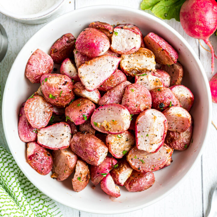 Roasted radishes in a white serving bowl.