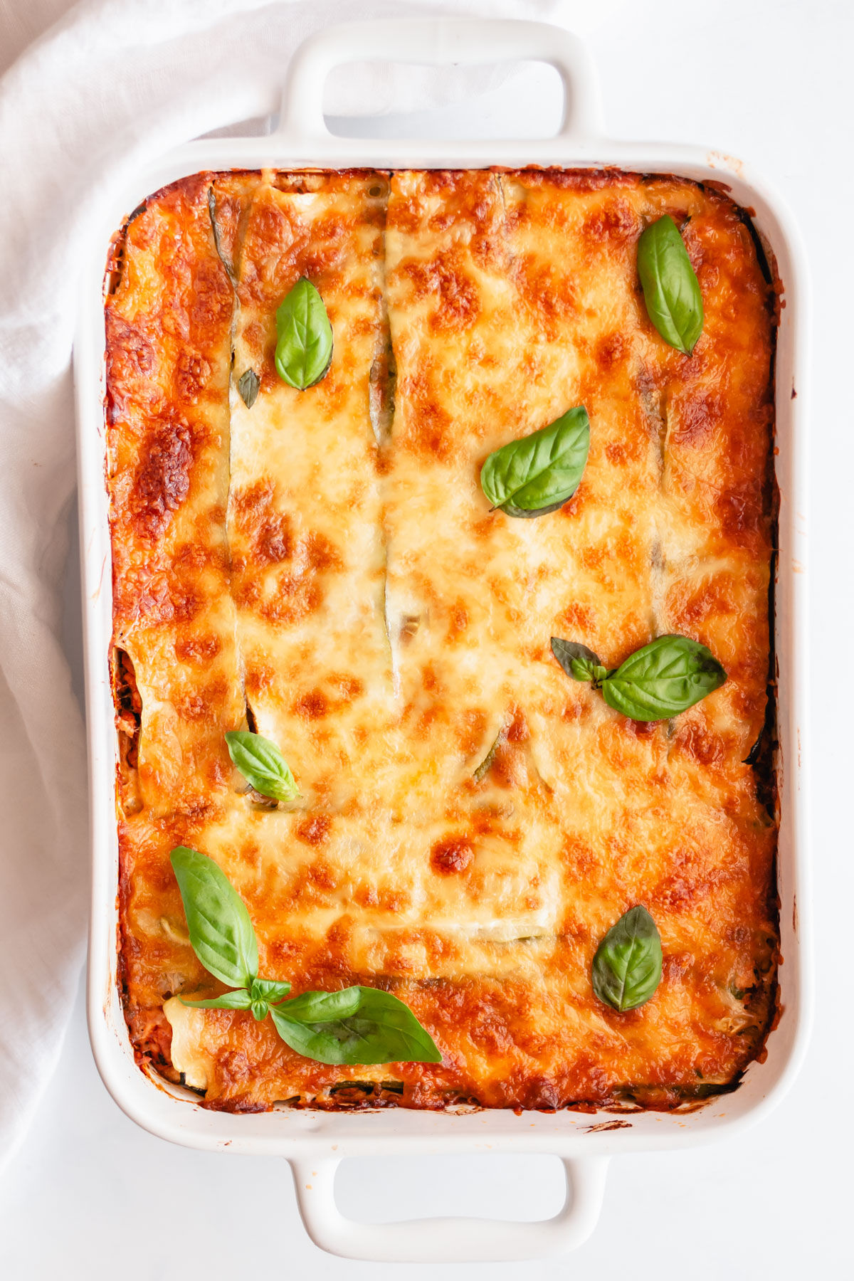 Zucchini lasagna in a white baking dish.