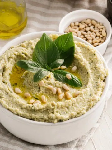 Make your veggie tray more exciting with Pesto Hummus. Chickpeas are blended with basil, pine nuts and garlic to create a flavorful hummus you can serve as a dip or spread.
