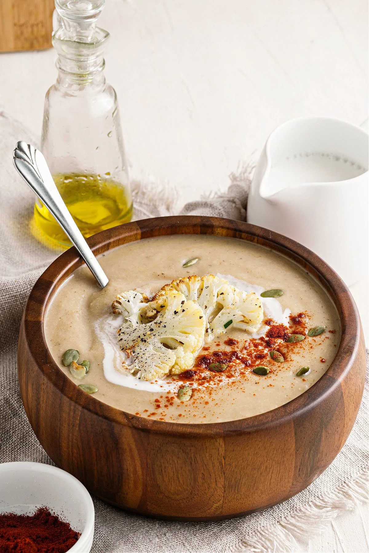 Bowl with cauliflower soup served with toppings.