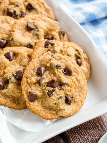 Chocolate chip cookies on white platter for serving.