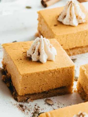 Pumpkin cheesecake with a dollop of whipped cream on top.