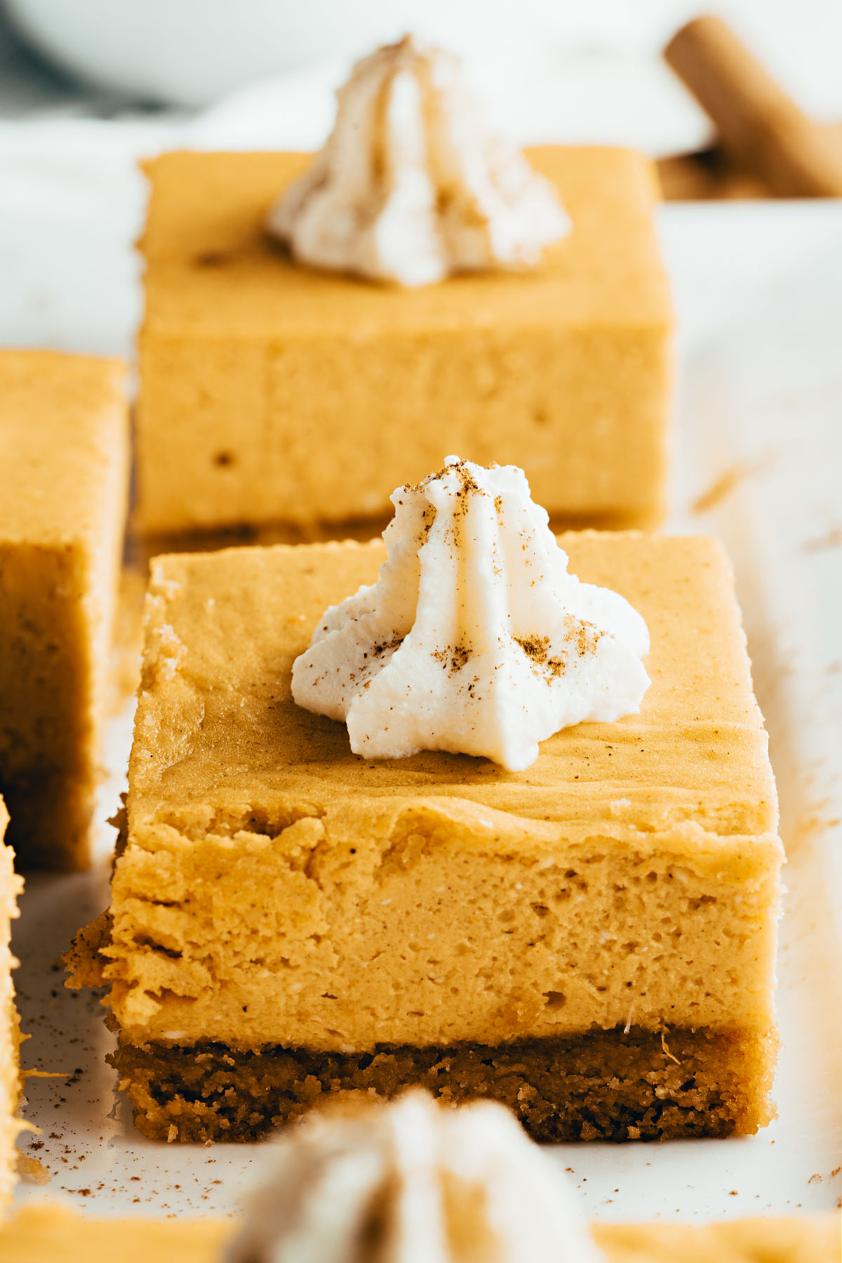 Keto pumpkin cheesecake squares with sugar free whipped cream.