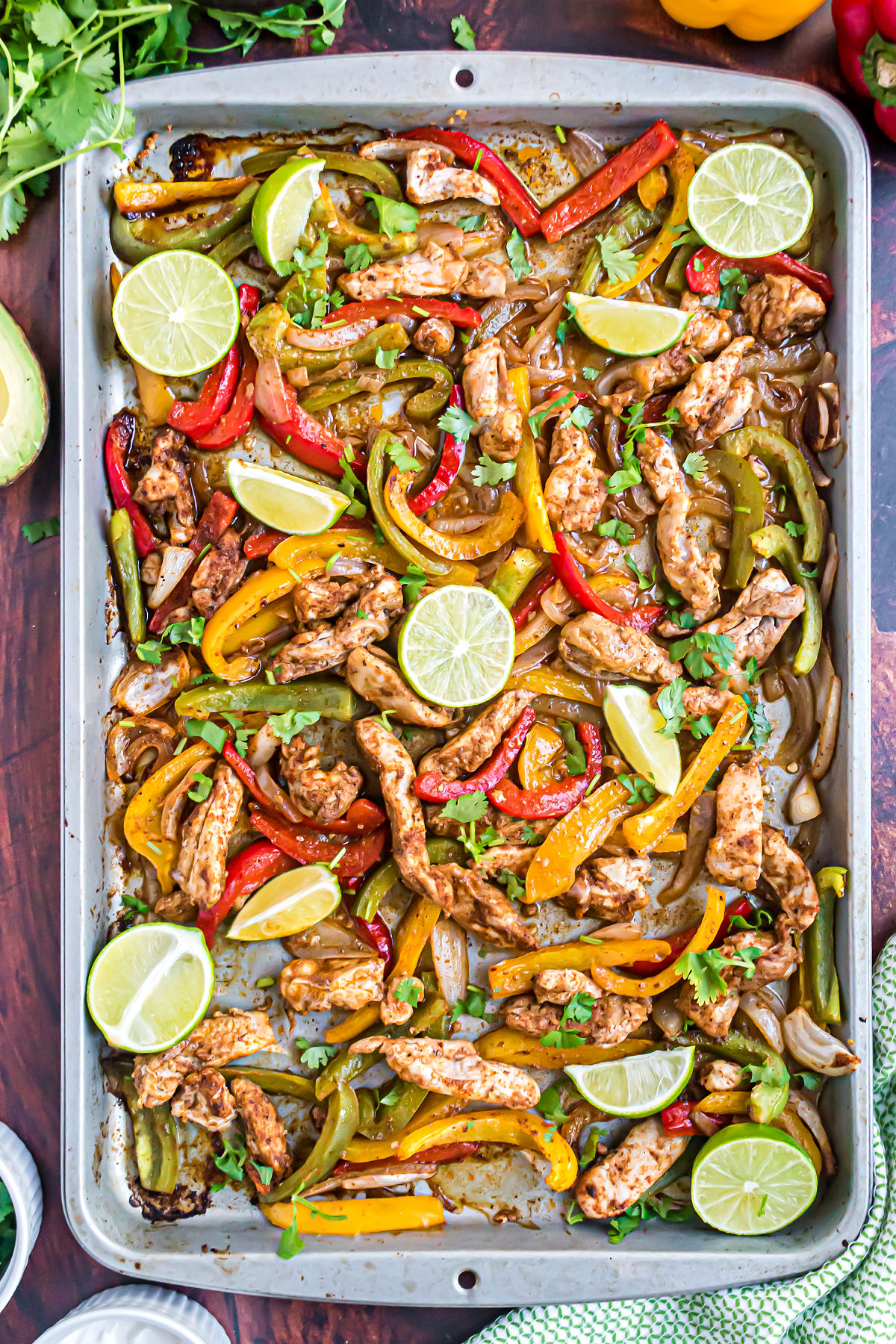 Sheet pan chicken fajitas baked and served with fresh lime slices.