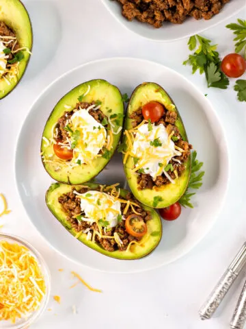 Avocados stuffed with taco filling and sour cream, cheese and tomatoes.