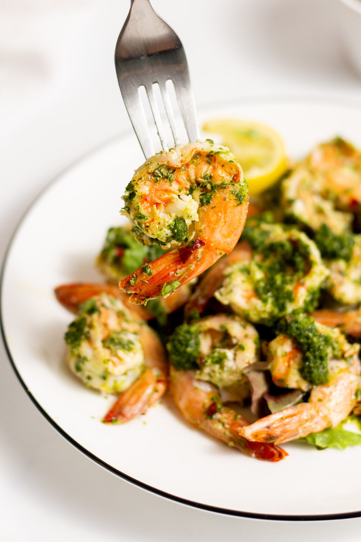 Grilled shrimp with chimichurri sauce on a fork.