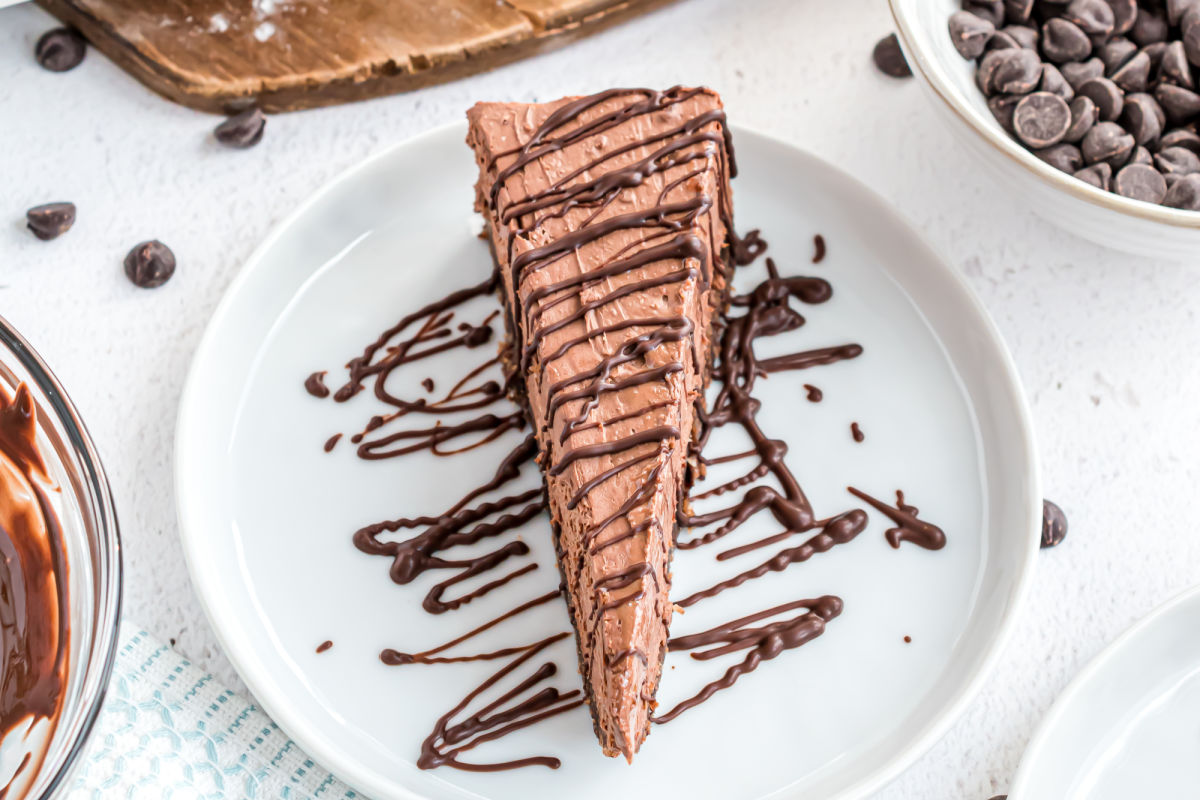 Slice of chocolate cheesecake drizzled with melted sugar free chocolate.