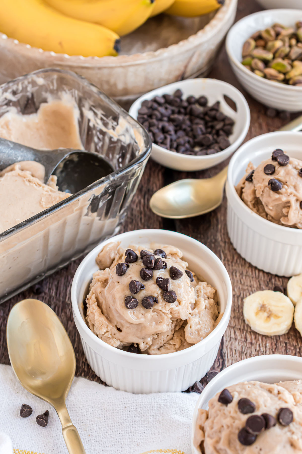 Chocolate chips on banana ice cream in a white bowl.