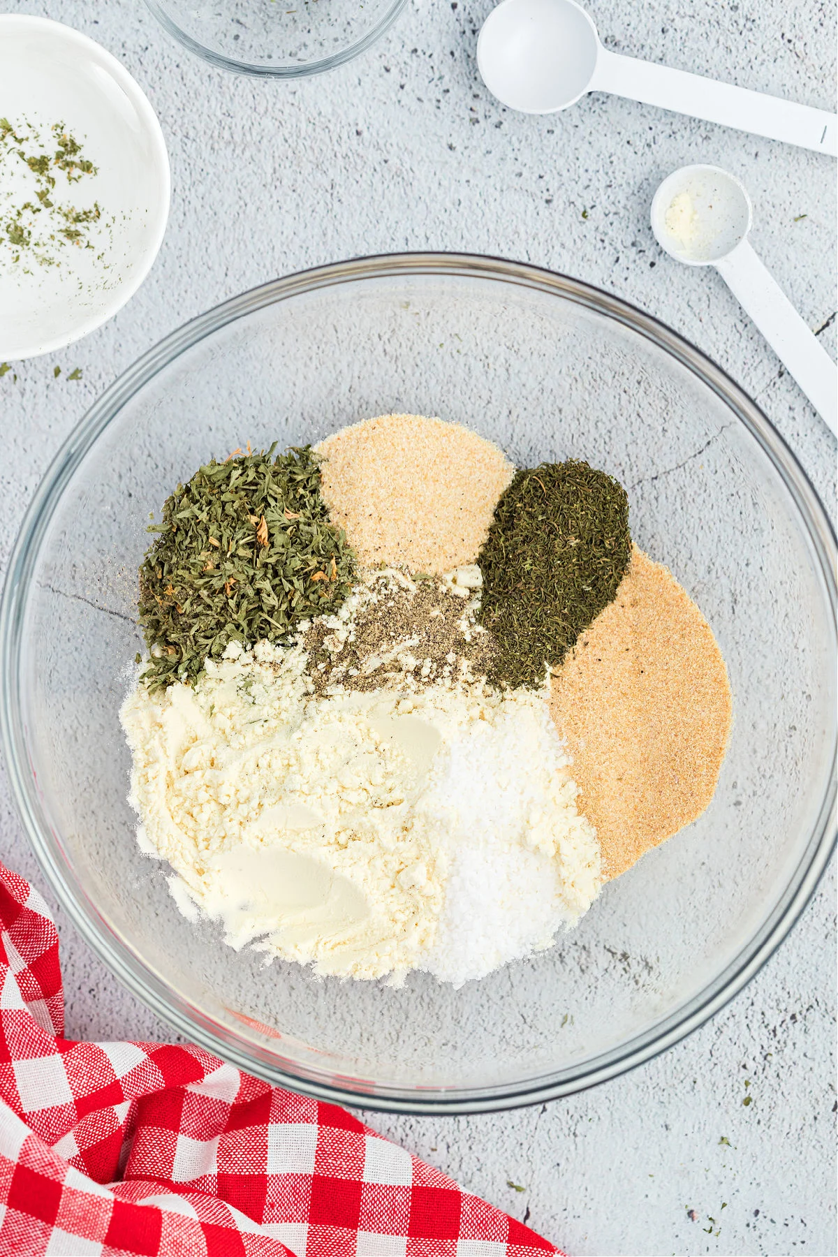 Seasonings for dry ranch dressing in a clear glass bowl.