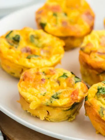 These easy Egg Bites taste like mini frittatas! Made in a muffin tin, they're filled with crispy bacon, fresh spinach and juicy tomatoes for a healthy breakfast or anytime snack.