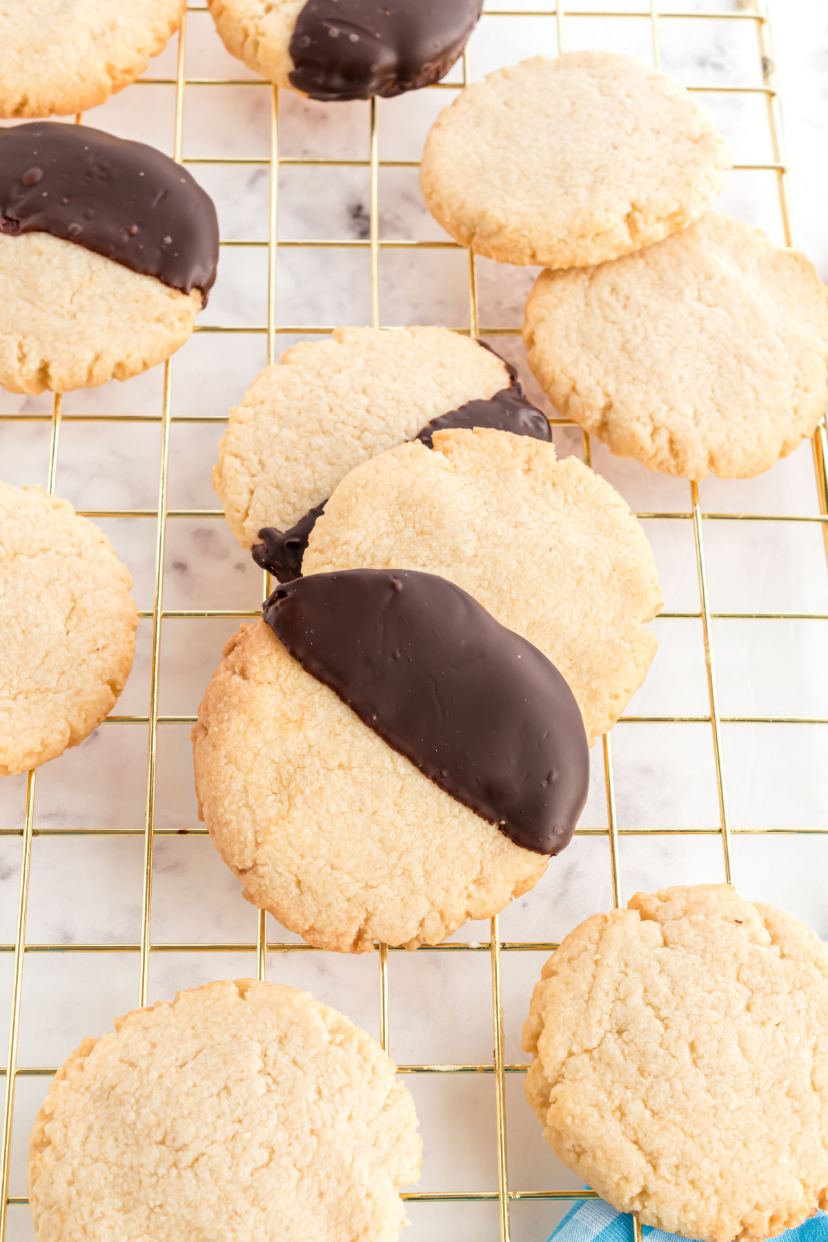 Shortbread cookies on wire cooling rack, some dipped in chocolate.