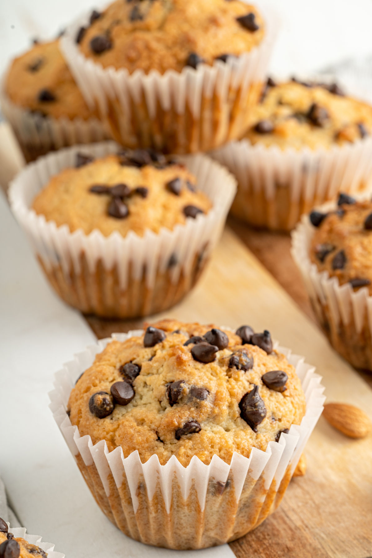 Chocolate chip muffins on a wooden board.