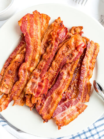 Cooked strips of bacon on a serving plate.