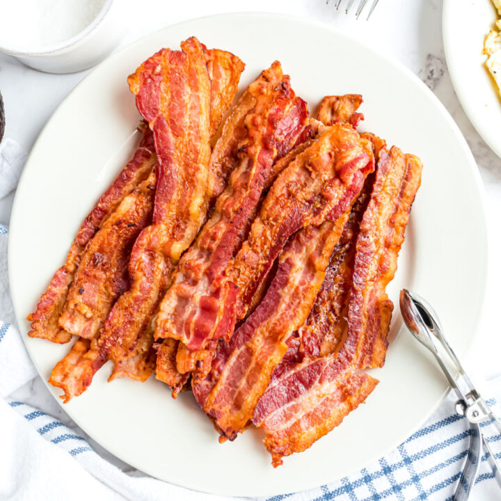 Cooked strips of bacon on a serving plate.
