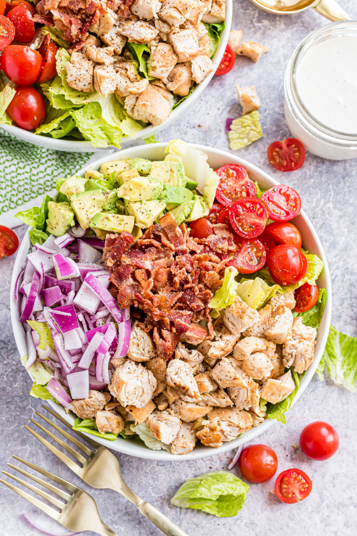 Chicken and bacon salad with avocado and tomatoes in a large bowl.