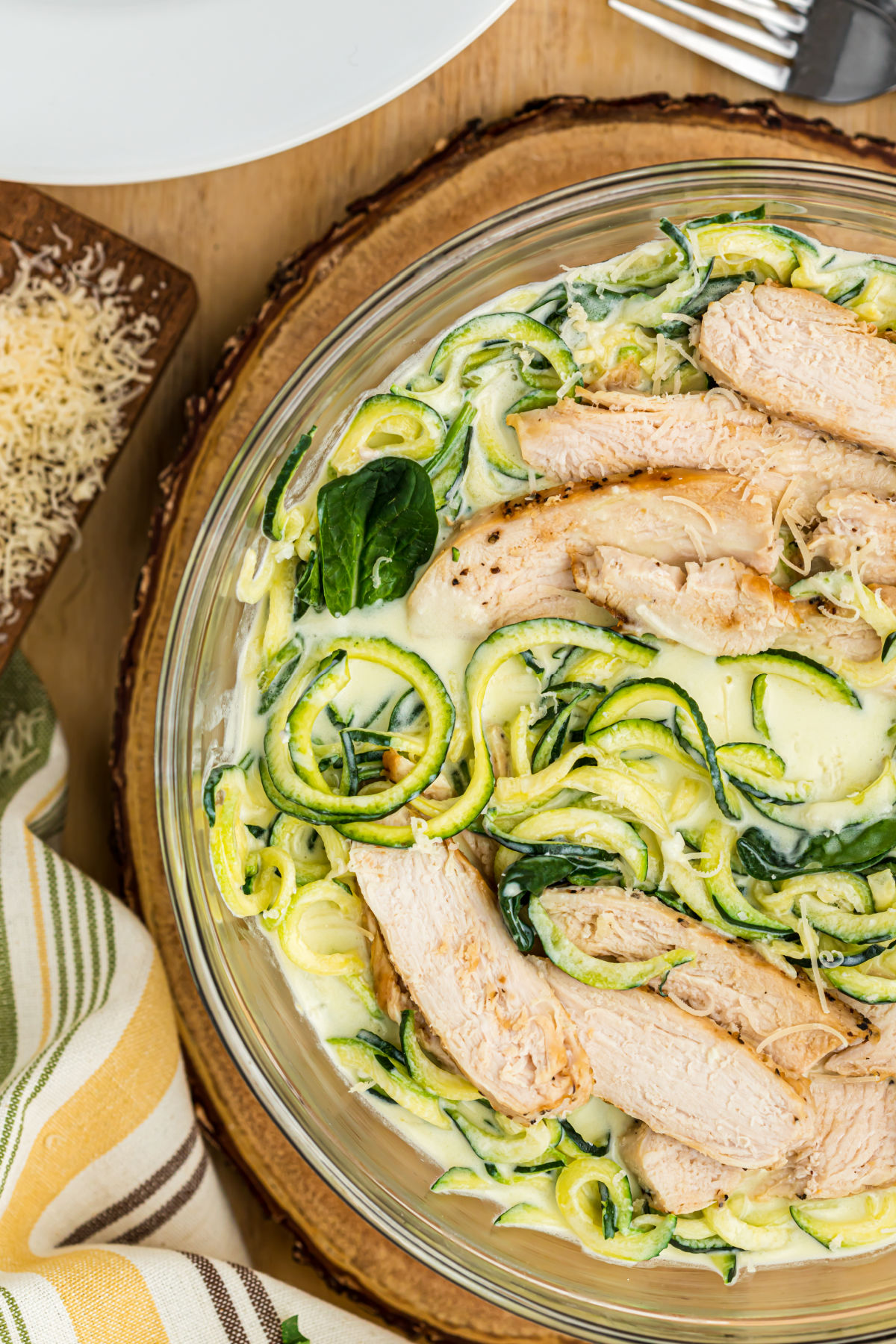 Chicken with zoodles and alfredo sauce in a skillet.