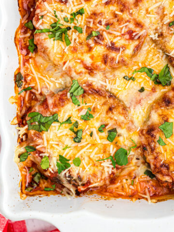 Eggplant parmesan baked in a white casserole dish.