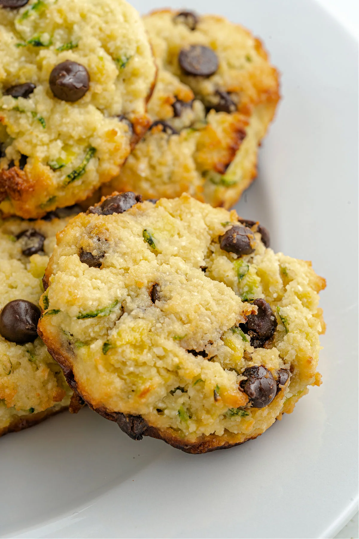 Chocolate chip cookies with zucchini on a white plate.