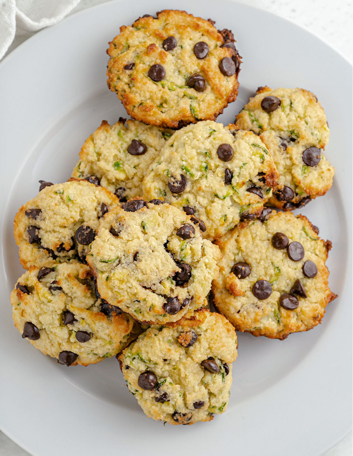 Chocolate chip zucchini cookies on a white serving plate.