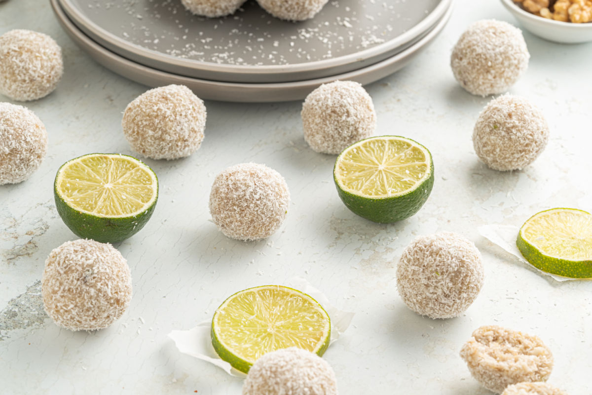Coconut engergy balls on counter with lime slices.