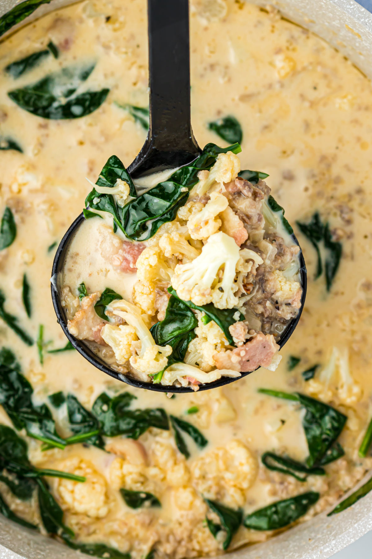 Ladle scooping up zuppa toscana soup.