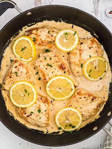 This skillet Lemon Garlic Chicken recipe is a healthy meal idea that's ready in 30 minutes! Your whole family will love the creamy garlic sauce and zesty fresh lemon in this easy keto chicken dinner.