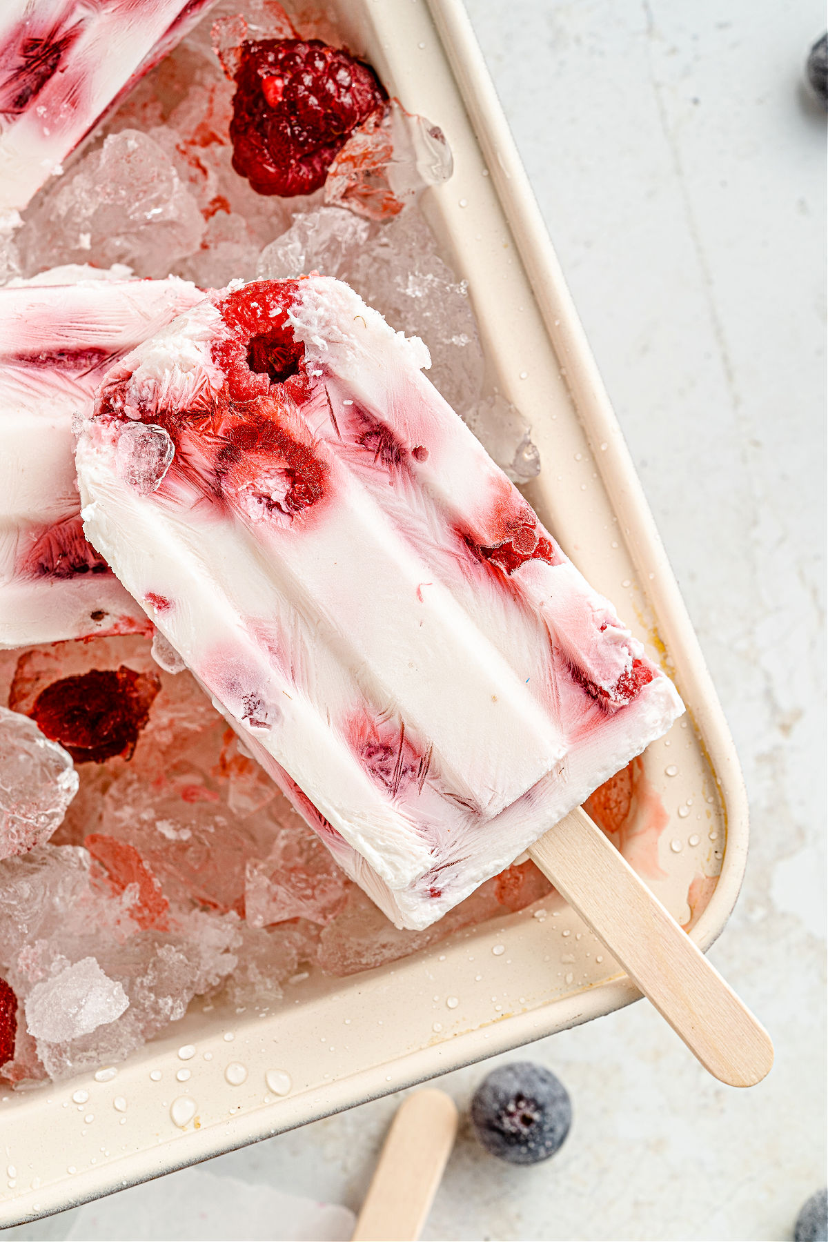 Raspberry yogurt popsicle on ice.