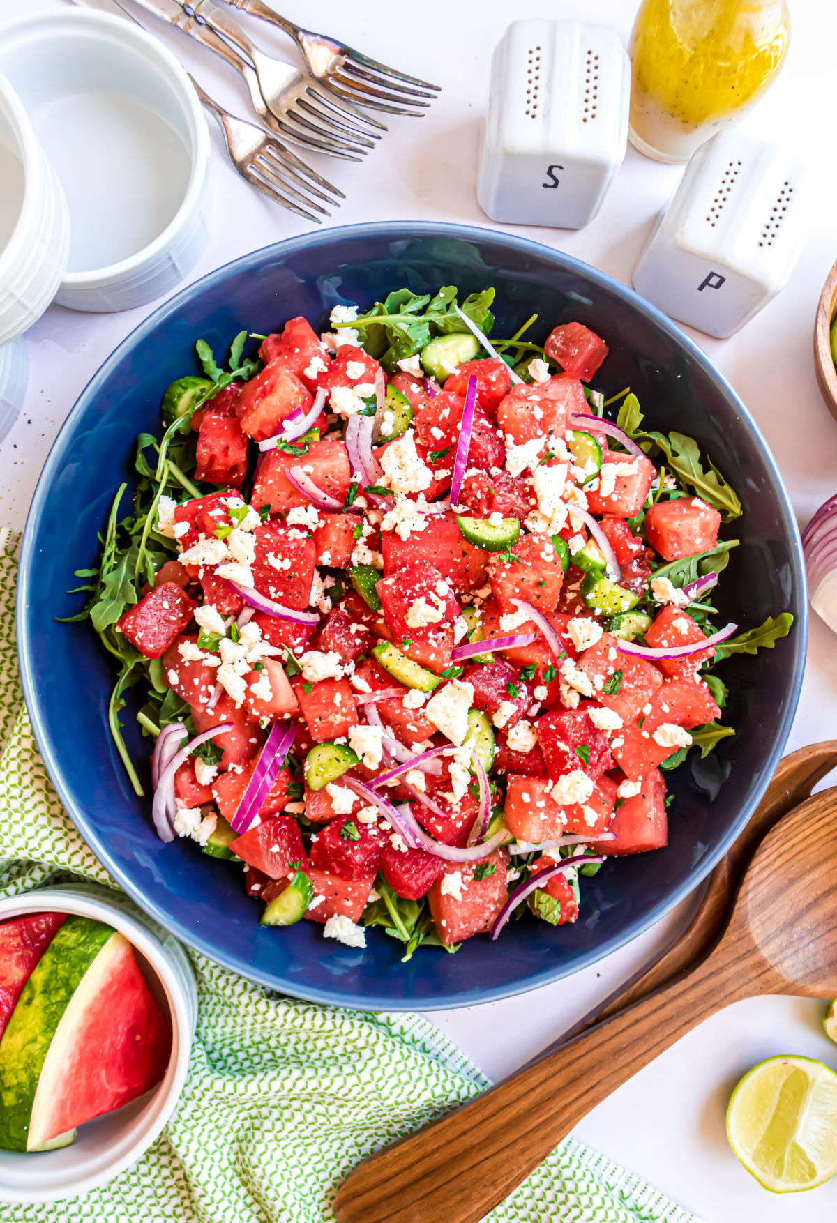 Watermelon salad served with feta cheese in a large blue bowl.