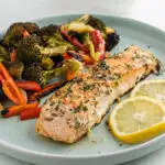 Garlic Butter Salmon is the perfect healthy sheet pan dinner! Tender salmon filets are basted with garlic butter sauce and baked with vegetables for a flavorful, nourishing meal.