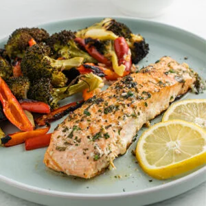 Garlic Butter Salmon is the perfect healthy sheet pan dinner! Tender salmon filets are basted with garlic butter sauce and baked with vegetables for a flavorful, nourishing meal.