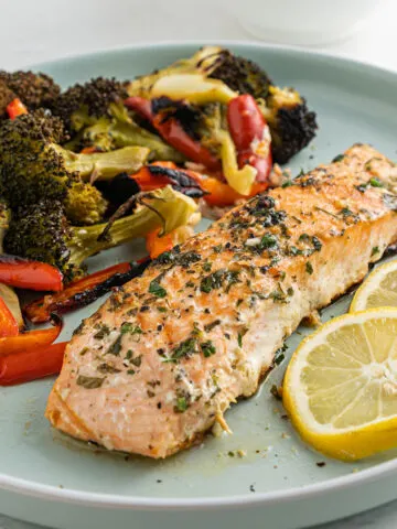 Garlic Butter Salmon is the perfect healthy sheet pan dinner! Tender salmon filets are basted with garlic butter sauce and baked with vegetables for a flavorful, nourishing meal.
