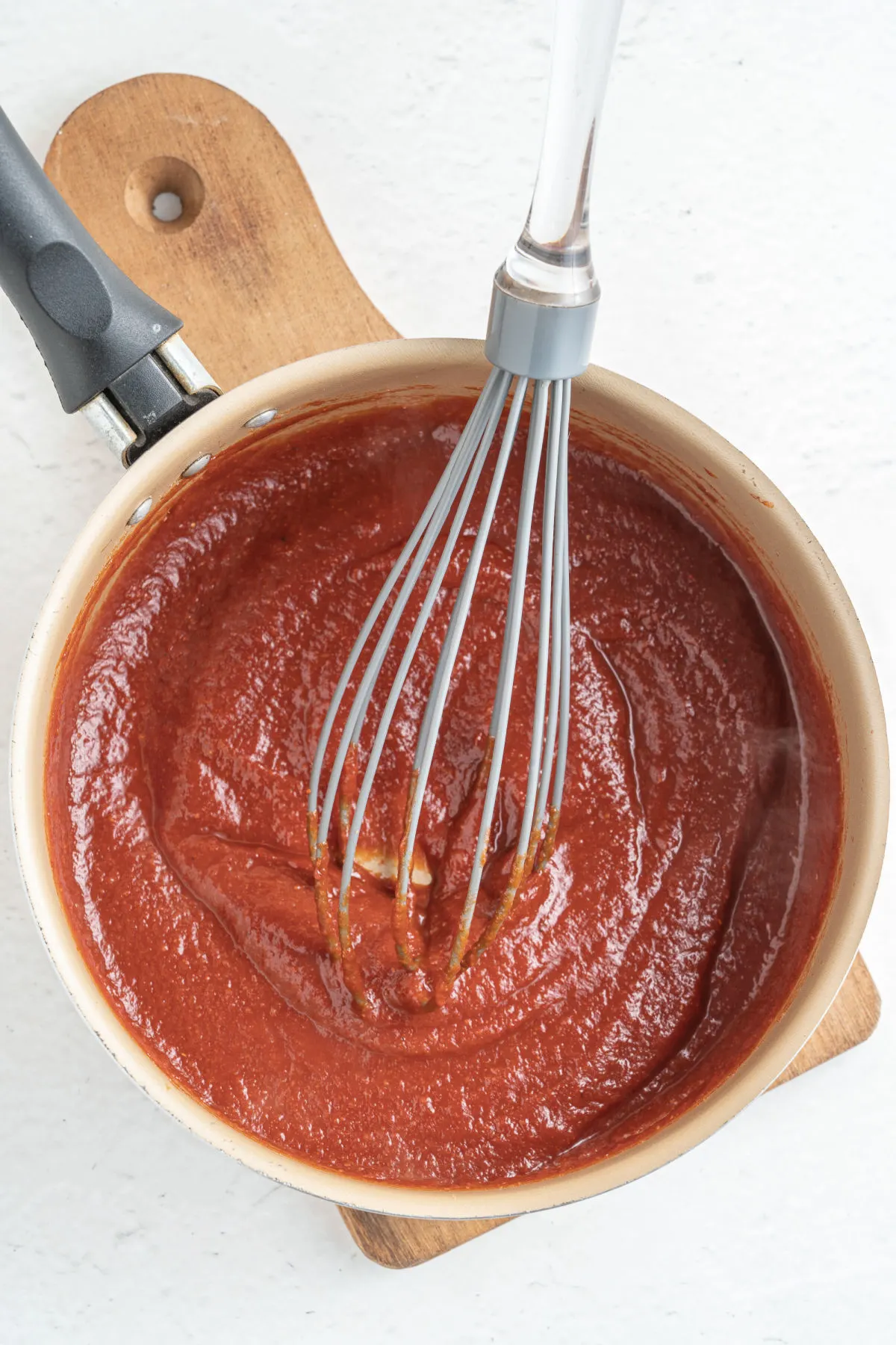 BBQ sauce in a saucepan with whisk.